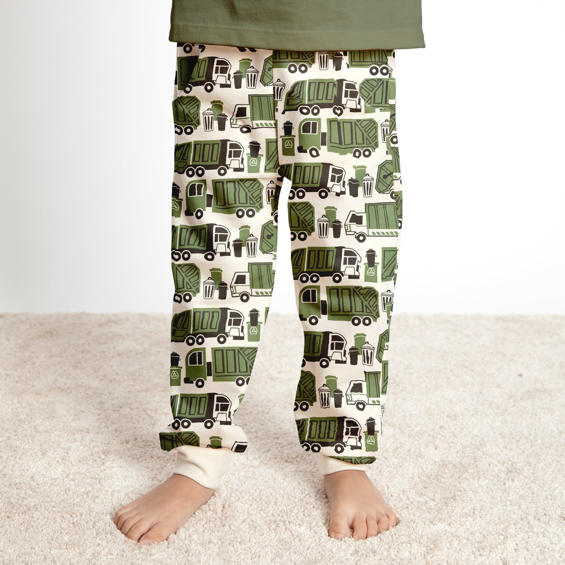 Child wearing green garbage and recycling truck print sweatpants, made with organic cotton