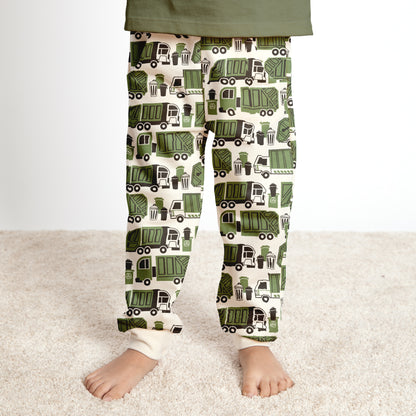 Child wearing green garbage and recycling truck print sweatpants, made with organic cotton